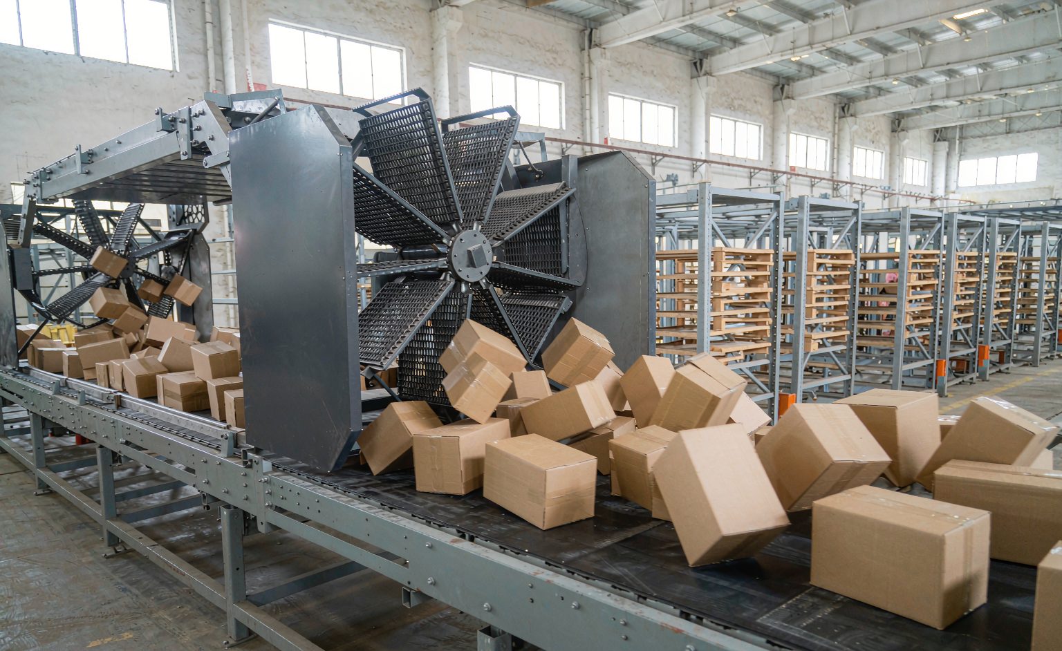 Swivel wheel sorter conveyor diverting cartons to takeaway lanes in a warehouse