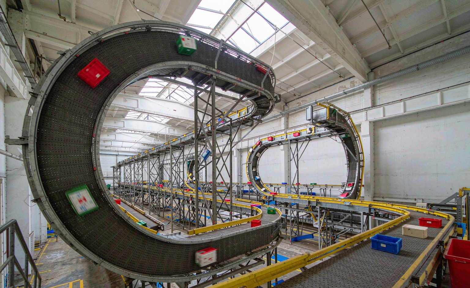 Wide view of a warehouse with a conveyor sortation loop and chute walls