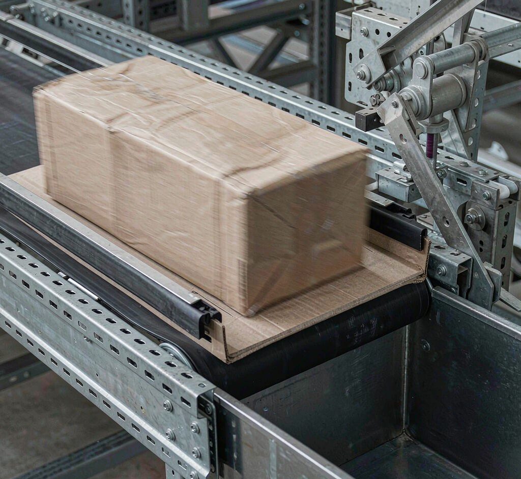 Parcel Diverted Into Sorter Chute Cardboard parcels being diverted by a cross belt sorter into a metal chute